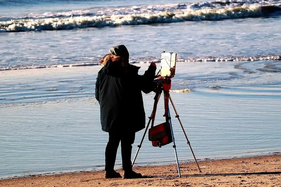 artist painging plein air on a beach